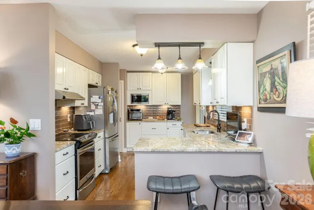a kitchen with a table chairs refrigerator and cabinets