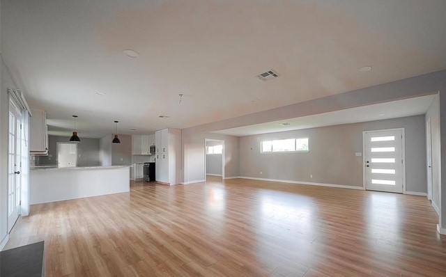 4800 Country Club View Baytown, TX 77521 - Photo 7 of 35 a view of an empty room and a kitchen with wooden floor