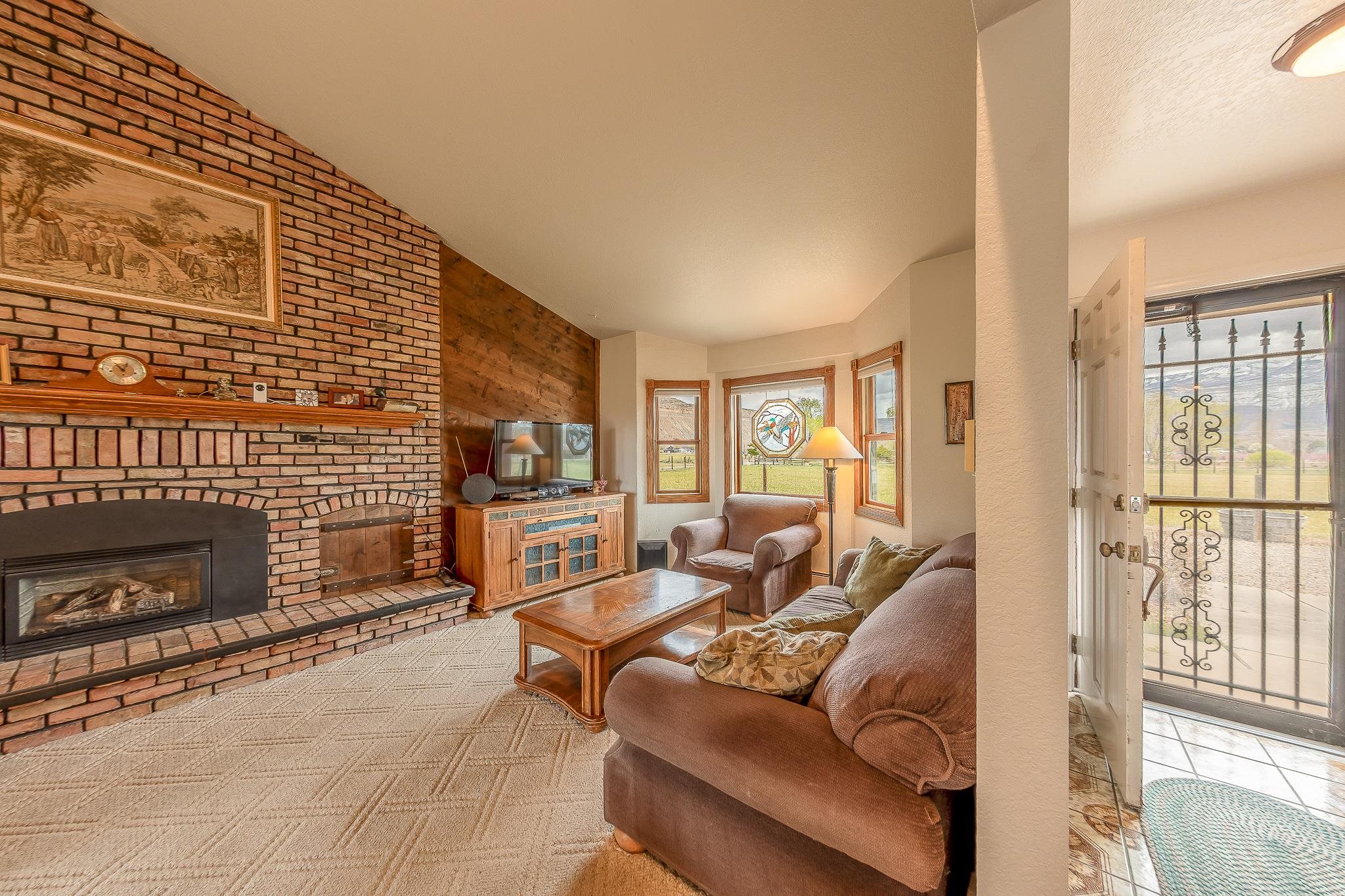 733-35 35 6/10 Road Palisade, CO 81526 - Photo 7 of 42 a living room with furniture a fireplace and a flat screen tv