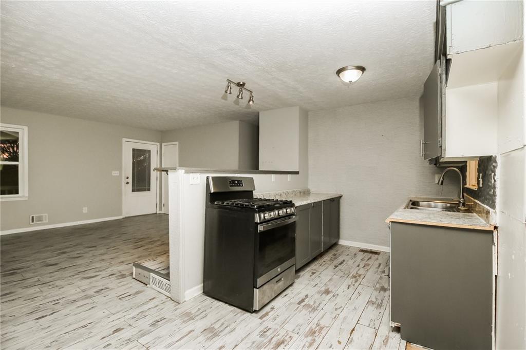 3864 McGill Lane Decatur, GA 30034 - Photo 9 of 25 a kitchen with granite countertop a sink cabinets and stainless steel appliances