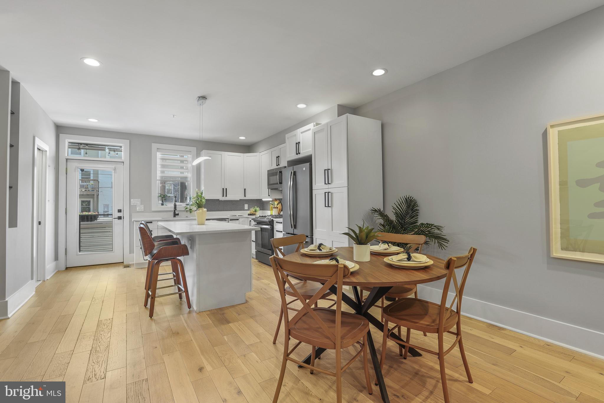 113 U Street Northeast, Unit 1 Washington, DC 20002 - Photo 12 of 63 a dining room with stainless steel appliances kitchen island a table and chairs in it
