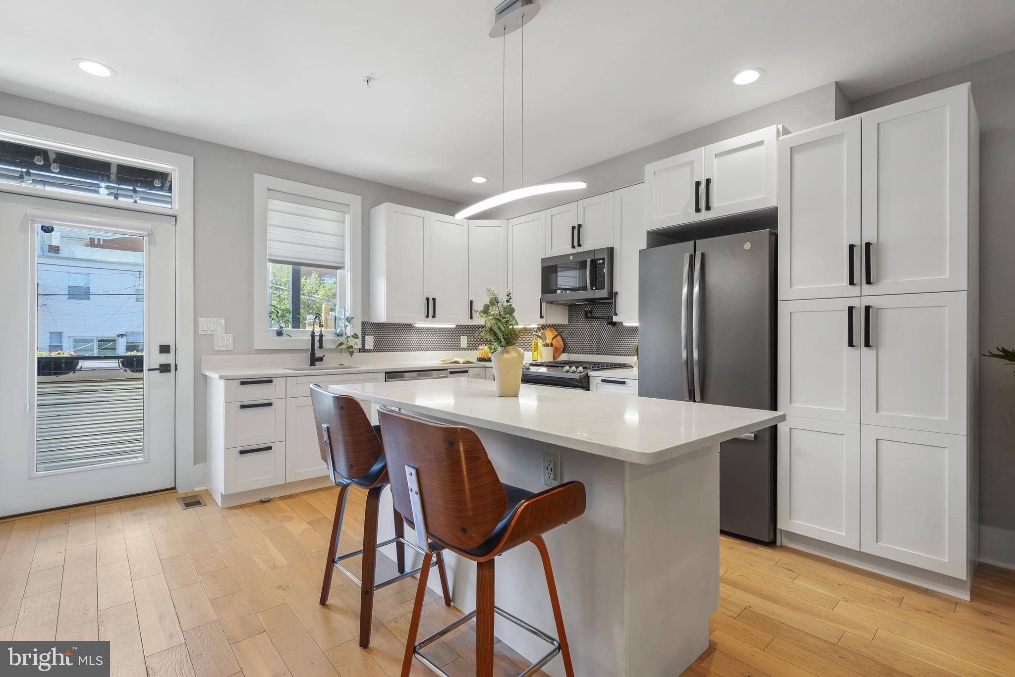 113 U Street Northeast, Unit 1 Washington, DC 20002 - Photo 16 of 63 a kitchen with white cabinets and stainless steel appliances
