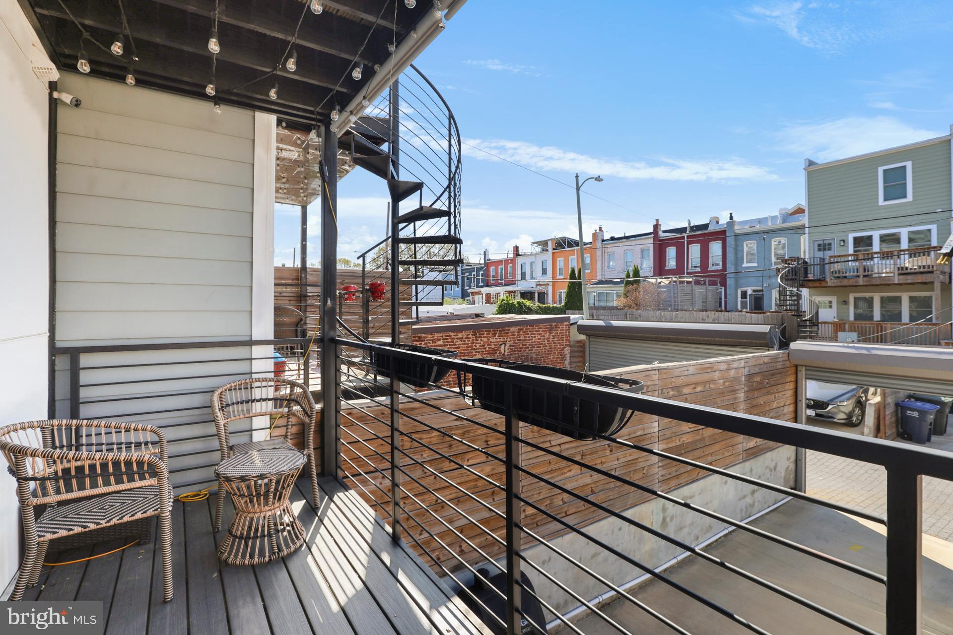 113 U Street Northeast, Unit 1 Washington, DC 20002 - Photo 27 of 63 a view of a balcony with wooden floor and iron fence