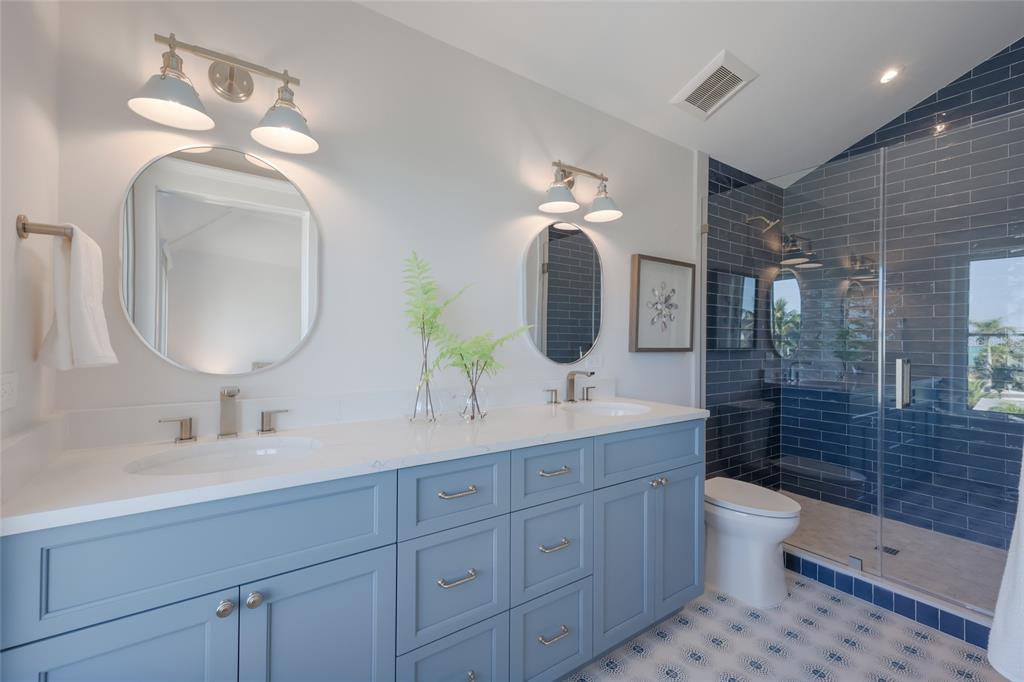 215 Sycamore Avenue Anna Maria, FL 34216 - Photo 50 of 75 a bathroom with a double vanity sink a toilet and a mirror