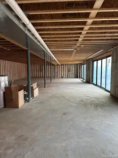 a view of an empty room with wooden floor and windows