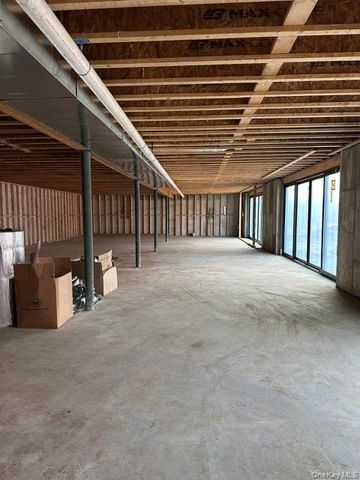 a view of an empty room with wooden floor and windows