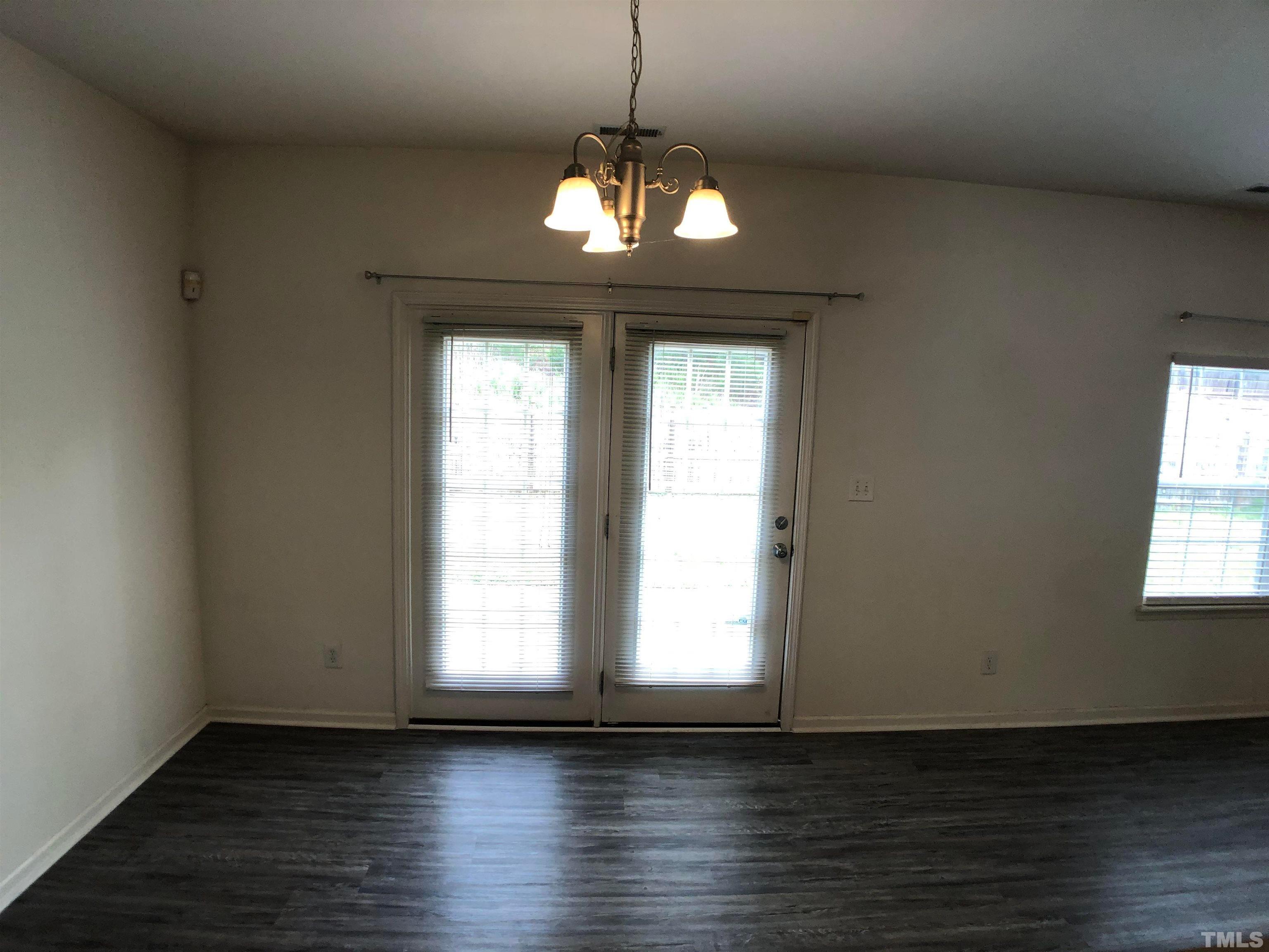 405 Hanson Road Durham, NC 27713 - Photo 9 of 27 a view of an empty room with wooden floor and a window
