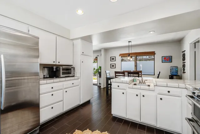 a kitchen with white cabinets and appliances