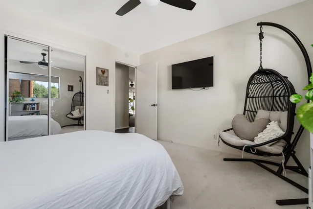 a bedroom with a bed a couch and a flat screen tv