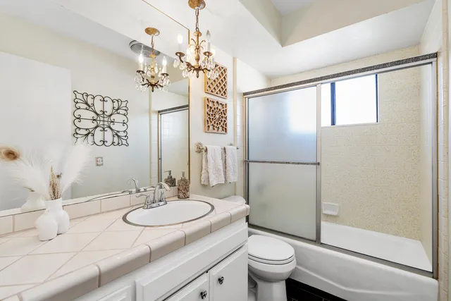 a bathroom with a granite countertop sink toilet and shower