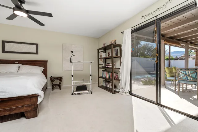 a bedroom with a bed and large window