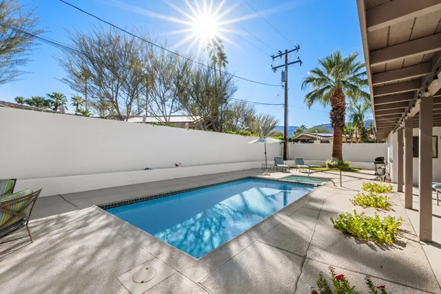 a view of swimming pool with outdoor seating and plants