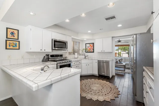 a kitchen that has a lot of cabinets in it and appliances