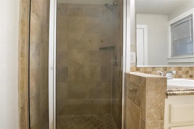 a bathroom with a granite countertop shower and a sink