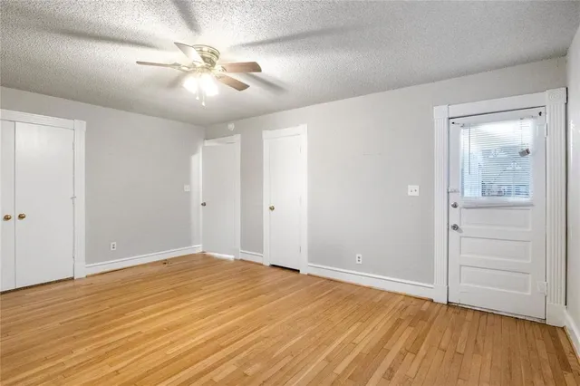 a view of empty room with wooden floor