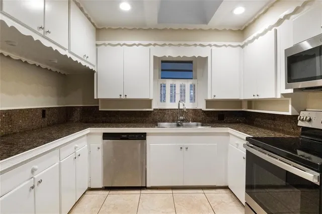 a kitchen with stainless steel appliances granite countertop a sink and a stove