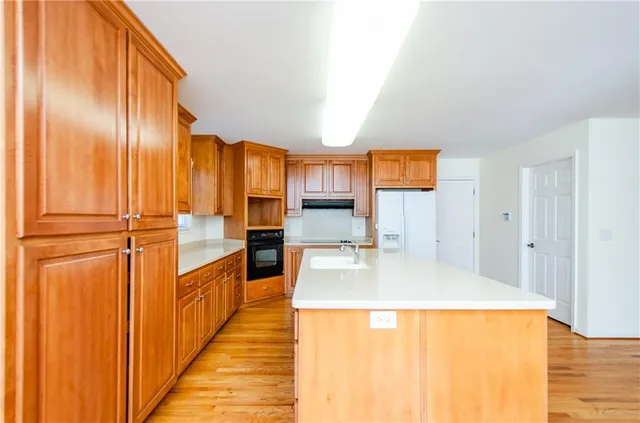 a kitchen with stainless steel appliances granite countertop a refrigerator a stove and a wooden cabinets