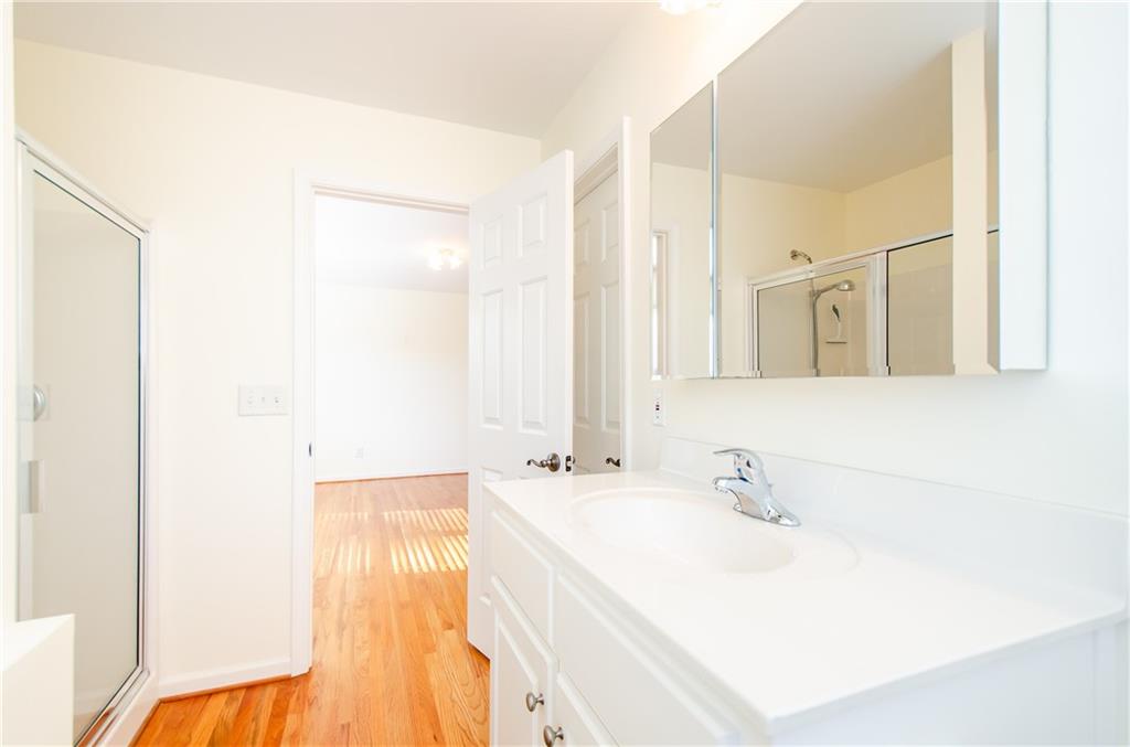 3950 Chattahoochee Road Cumming, GA 30041 - Photo 28 of 45 a bathroom with a sink a mirror and a shower