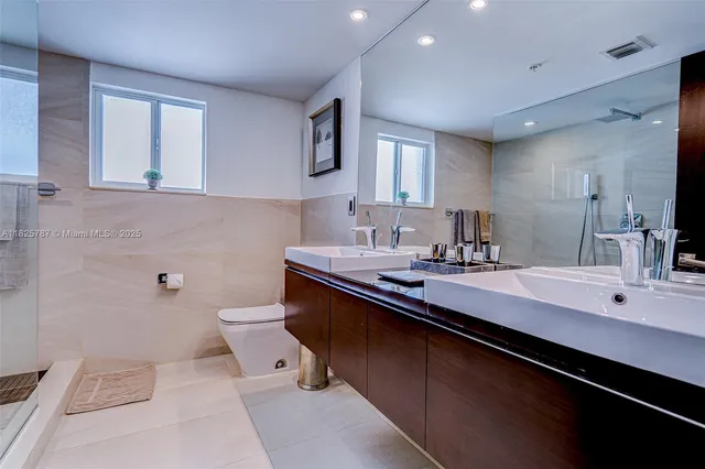 a bathroom with a sink a toilet and mirror