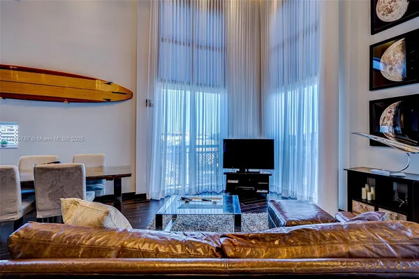 a living room with furniture a flat screen tv and a fireplace
