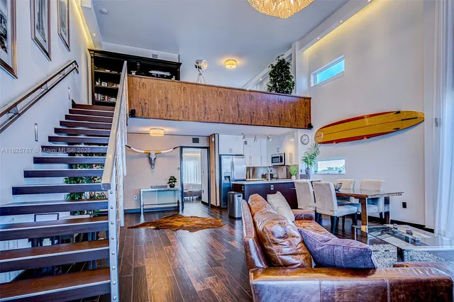 a living room with furniture kitchen view and a large window