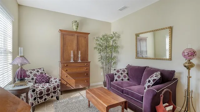 a living room with furniture a flat screen tv and a chandelier