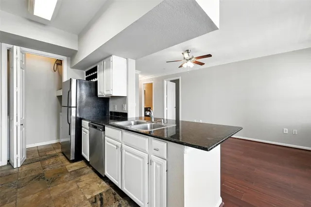 a kitchen with stainless steel appliances granite countertop a sink refrigerator and microwave