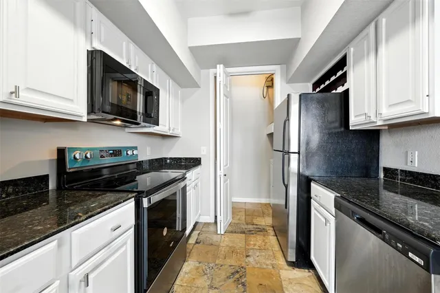 a kitchen with stainless steel appliances granite countertop a stove microwave refrigerator and sink