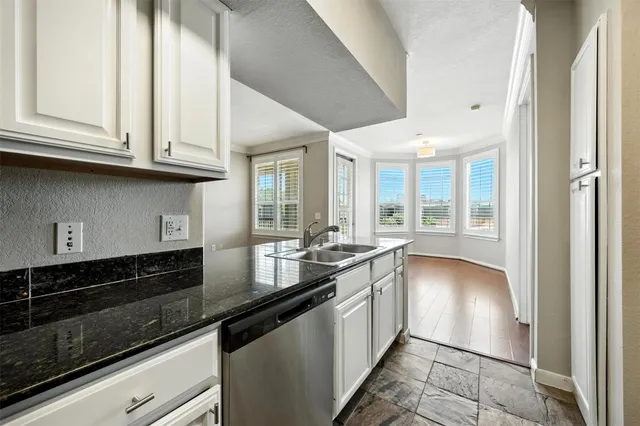 a kitchen with granite countertop a sink and cabinets