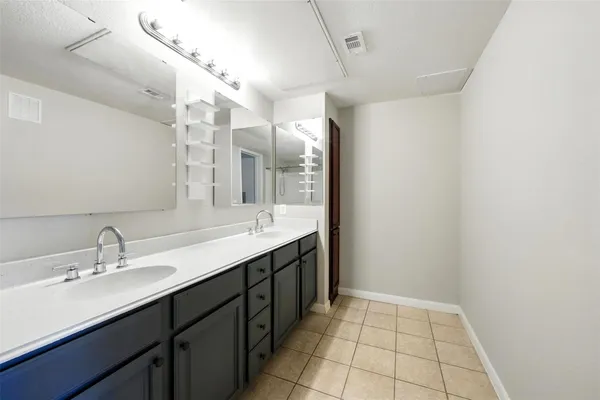 a bathroom with a double vanity sink and a mirror