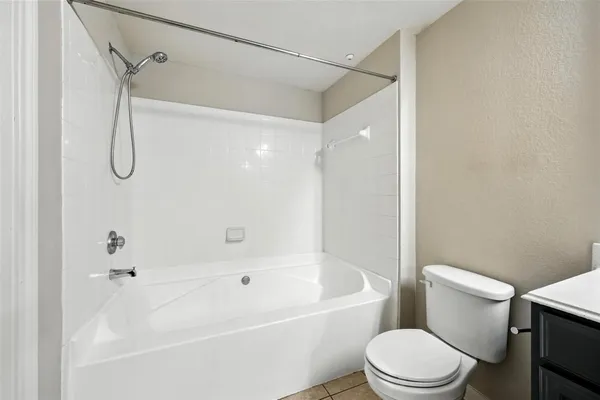 a white toilet sitting next to a bath tub and shower