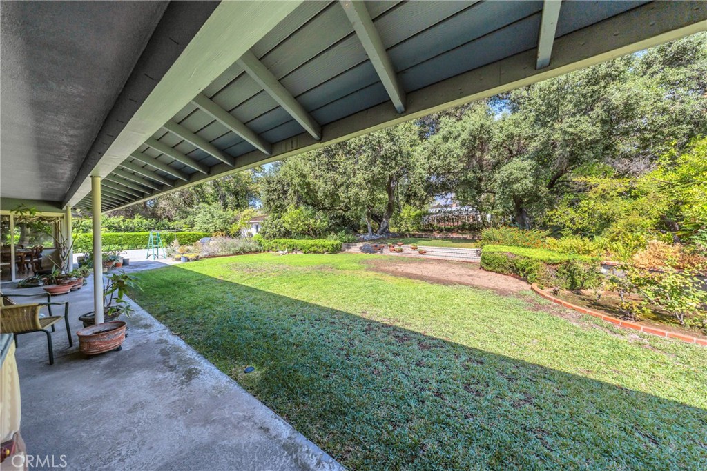 827 Hampton Road Arcadia, CA 91006 - Photo 17 of 37 a view of a backyard with table and chairs under an umbrella with a small yard