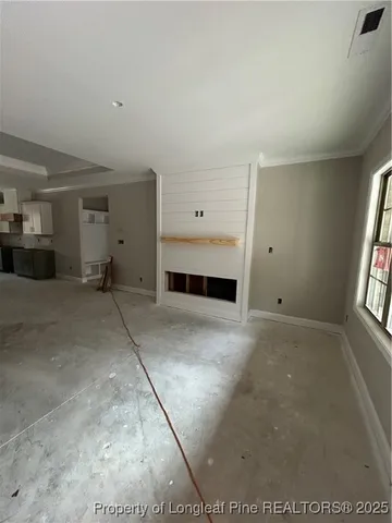 a view of empty room with window and fireplace