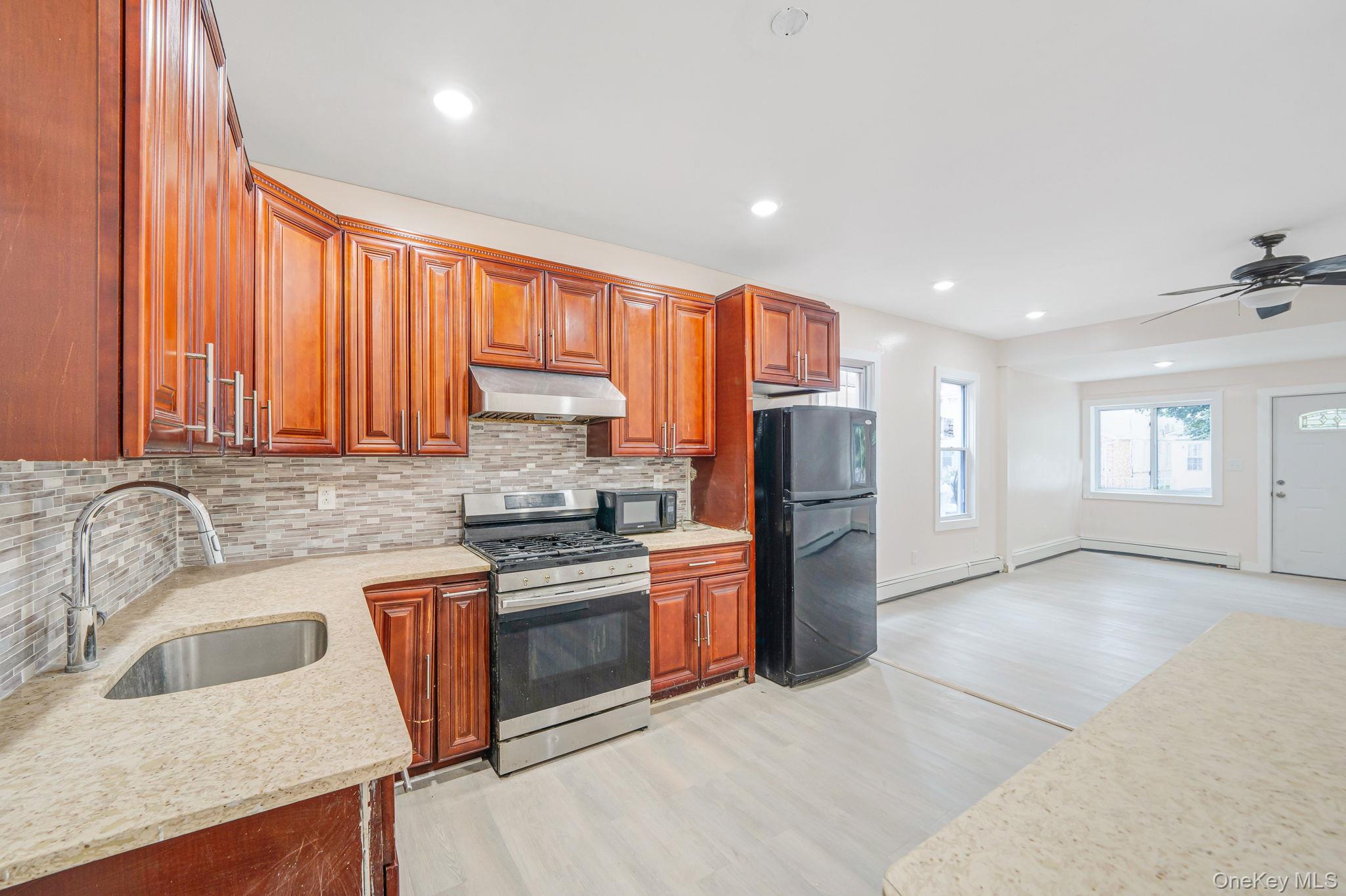 101-31 116th Street Queens, NY 11419 - Photo 14 of 19 a kitchen with stainless steel appliances granite countertop a refrigerator sink and stove