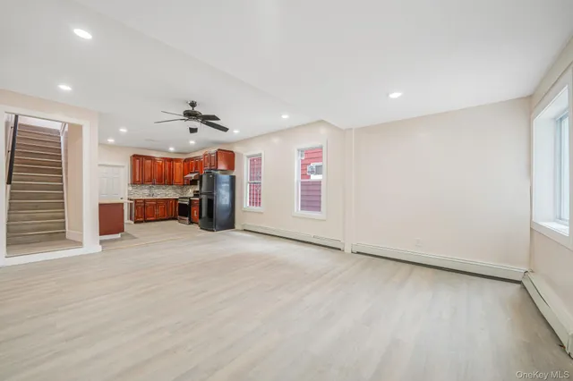 an empty room with furniture and a kitchen
