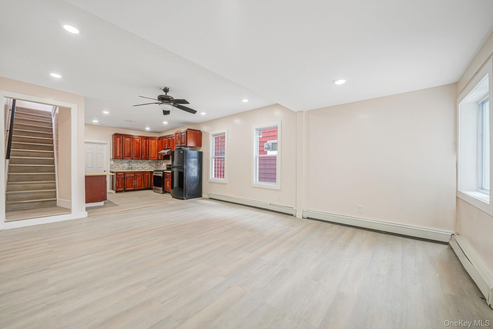 101-31 116th Street Queens, NY 11419 - Photo 17 of 19 an empty room with furniture and a kitchen