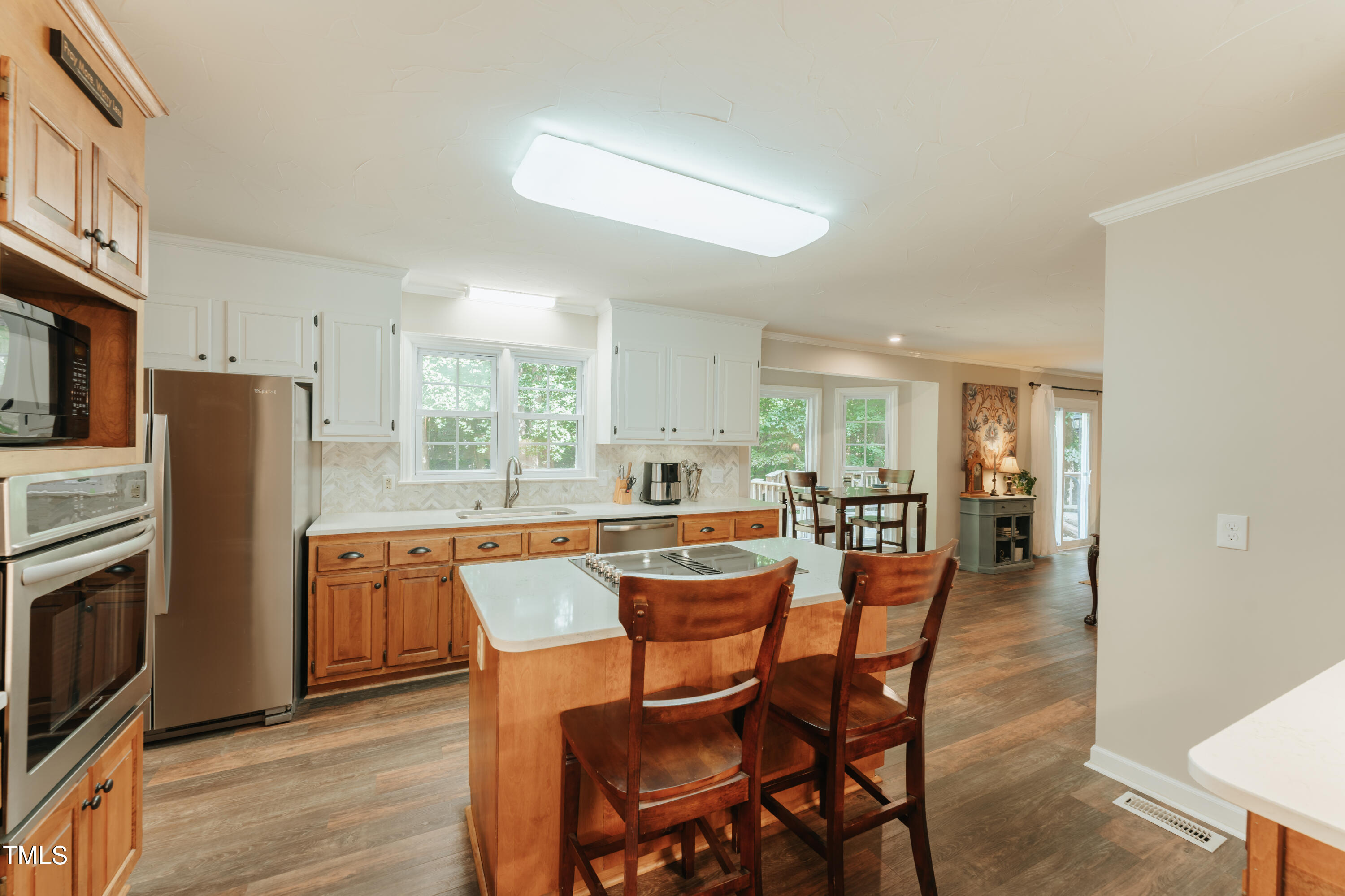 55 Sycamore Road Roxboro, NC 27574 - Photo 45 of 73 a dining hall with stainless steel appliances granite countertop a refrigerator a stove a sink dishwasher and white cabinets with wooden floor