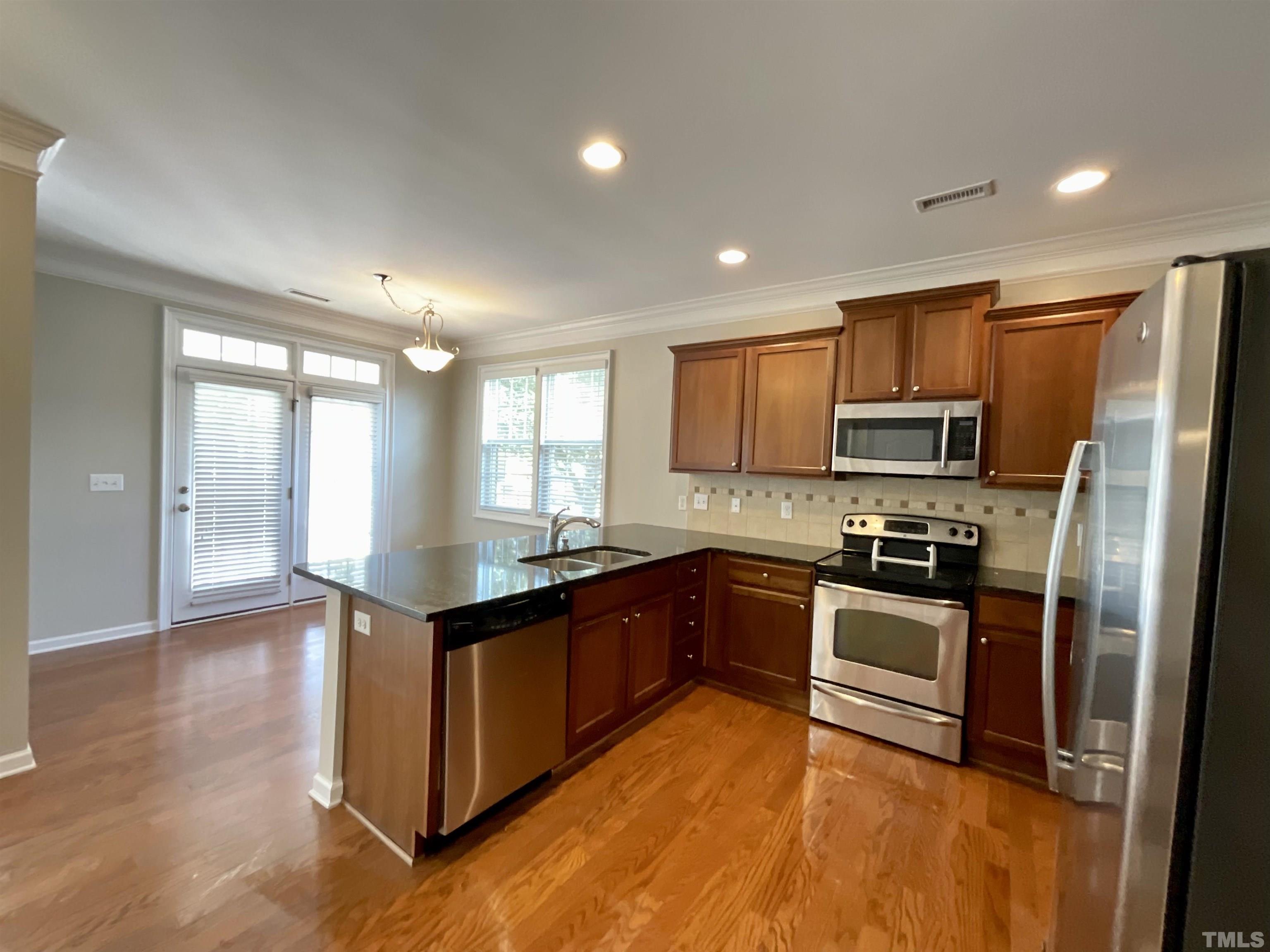 2632 Cloud Mist Circle Raleigh, NC 27614 - Photo 13 of 25 a kitchen with stainless steel appliances granite countertop a stove top oven a sink dishwasher a refrigerator and cabinets with wooden floor