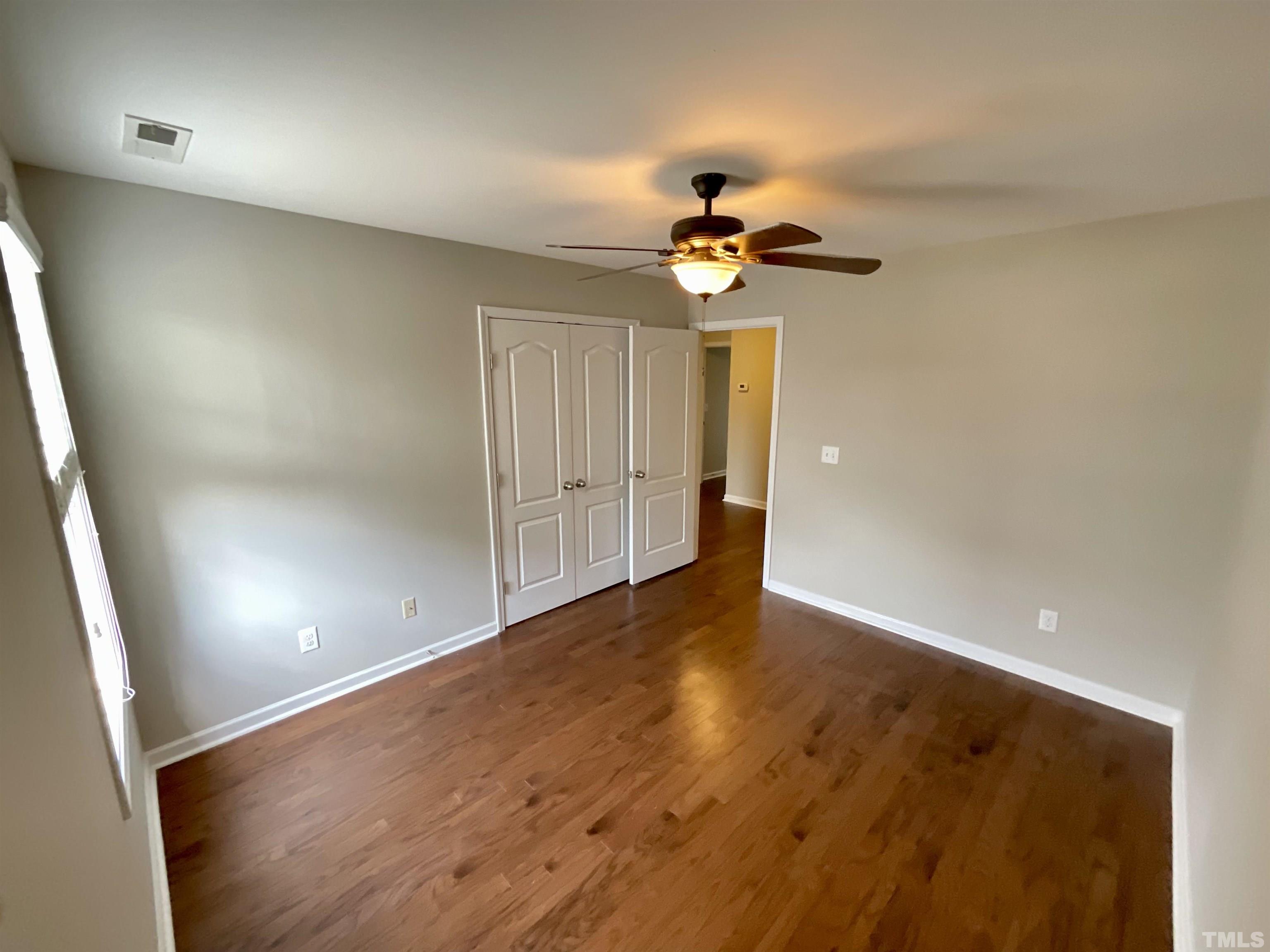 2632 Cloud Mist Circle Raleigh, NC 27614 - Photo 20 of 25 an empty room with a chandelier fan and wooden floor