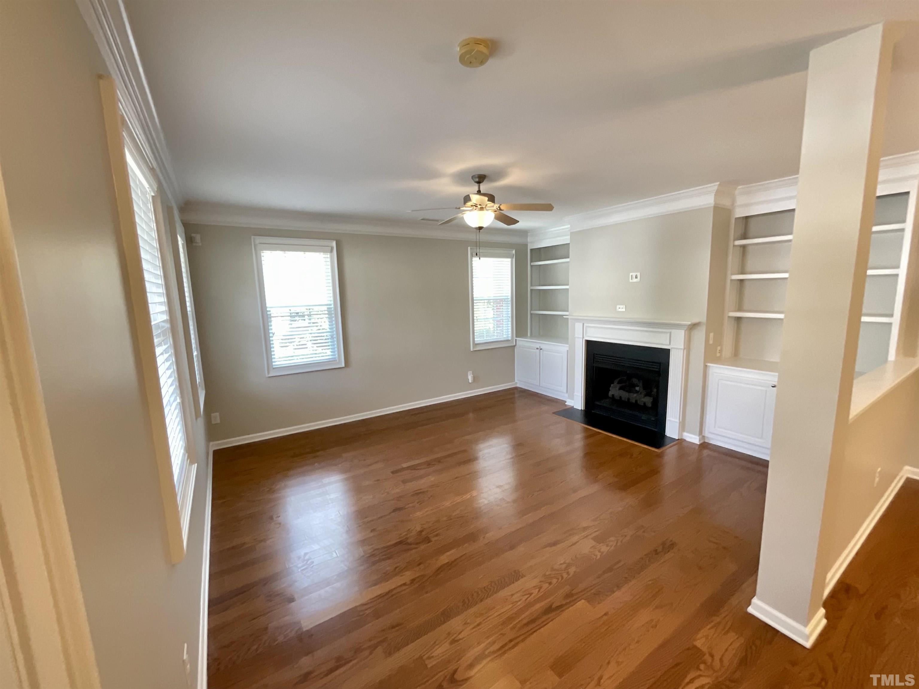 2632 Cloud Mist Circle Raleigh, NC 27614 - Photo 3 of 25 an empty room with wooden floor fireplace and windows