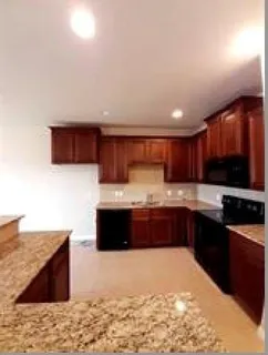 a large kitchen with stainless steel appliances wooden cabinets and a sink