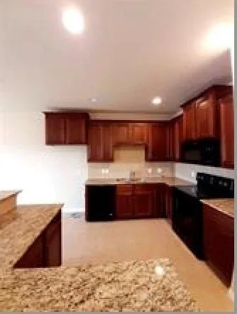 a large kitchen with stainless steel appliances wooden cabinets and a sink