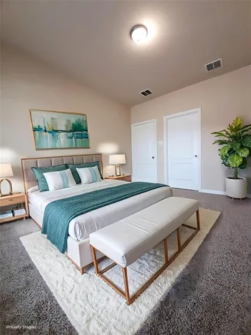 a bedroom with a bed a table and potted plant