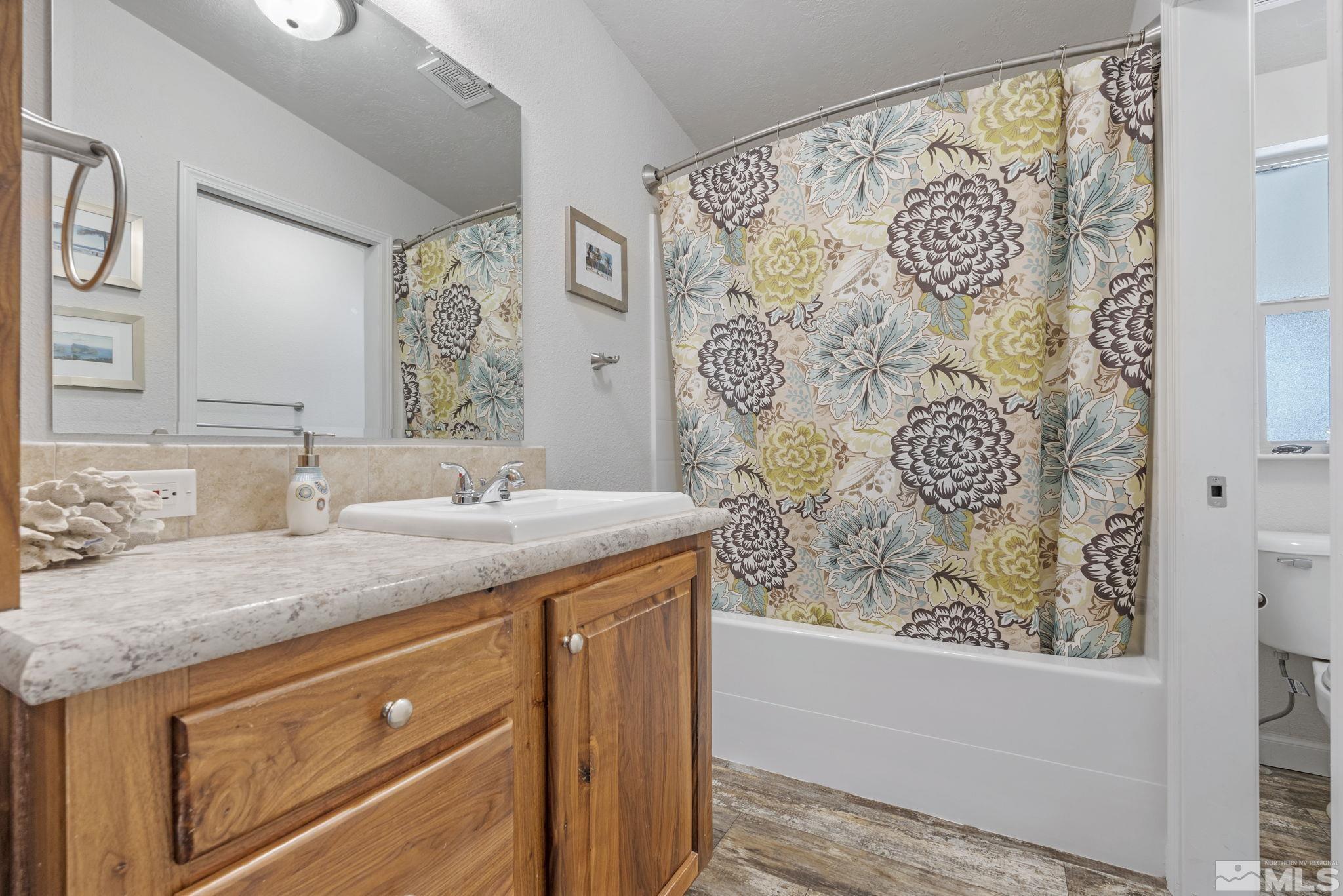 15153 Kivett Lane Reno, NV 89521 - Photo 10 of 16 a bathroom with a granite countertop sink and a mirror