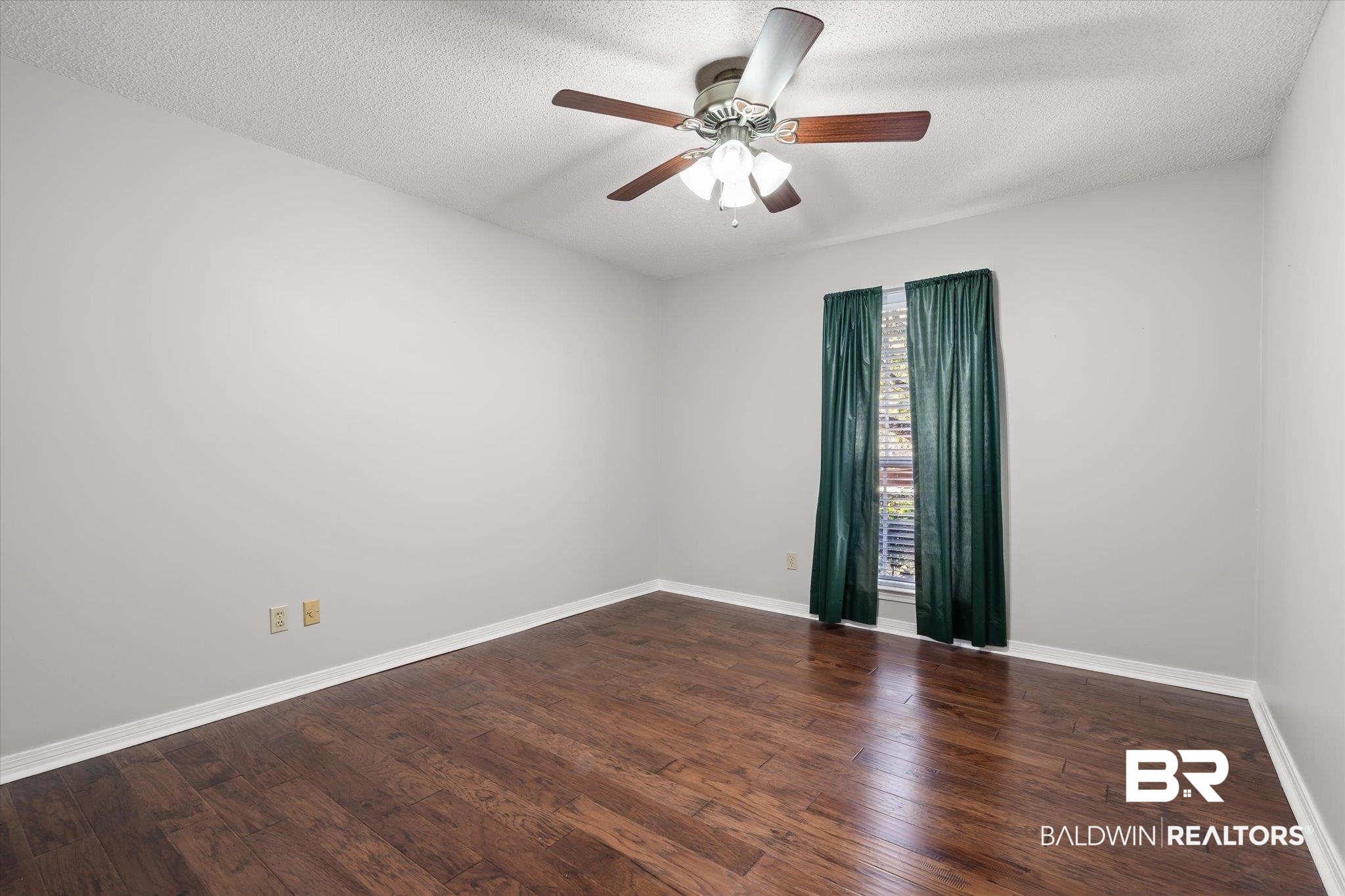 7410 East Lakeview Drive Mobile, AL 36695 - Photo 13 of 20 Spare room with dark hardwood / wood-style floors, ceiling fan, and a textured ceiling