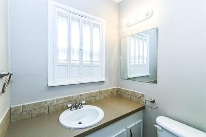2711 22nd Street Lubbock, TX 79410 - Photo 18 of 28 a bathroom with a sink a toilet and a mirror