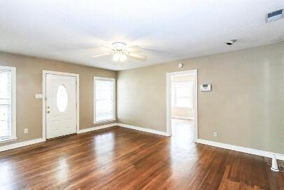2711 22nd Street Lubbock, TX 79410 - Photo 10 of 28 a view of an empty room with wooden floor and a window