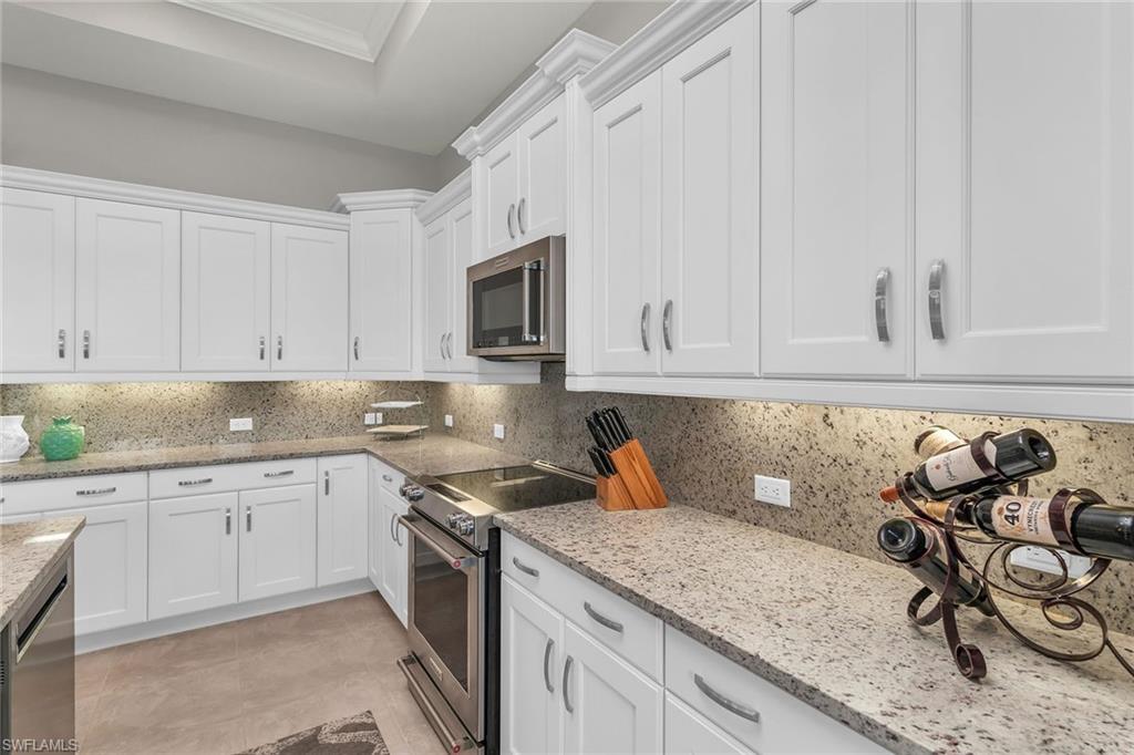 14812 Dockside Lane Naples, FL 34114 - Photo 12 of 49 a kitchen with sink cabinets and microwave