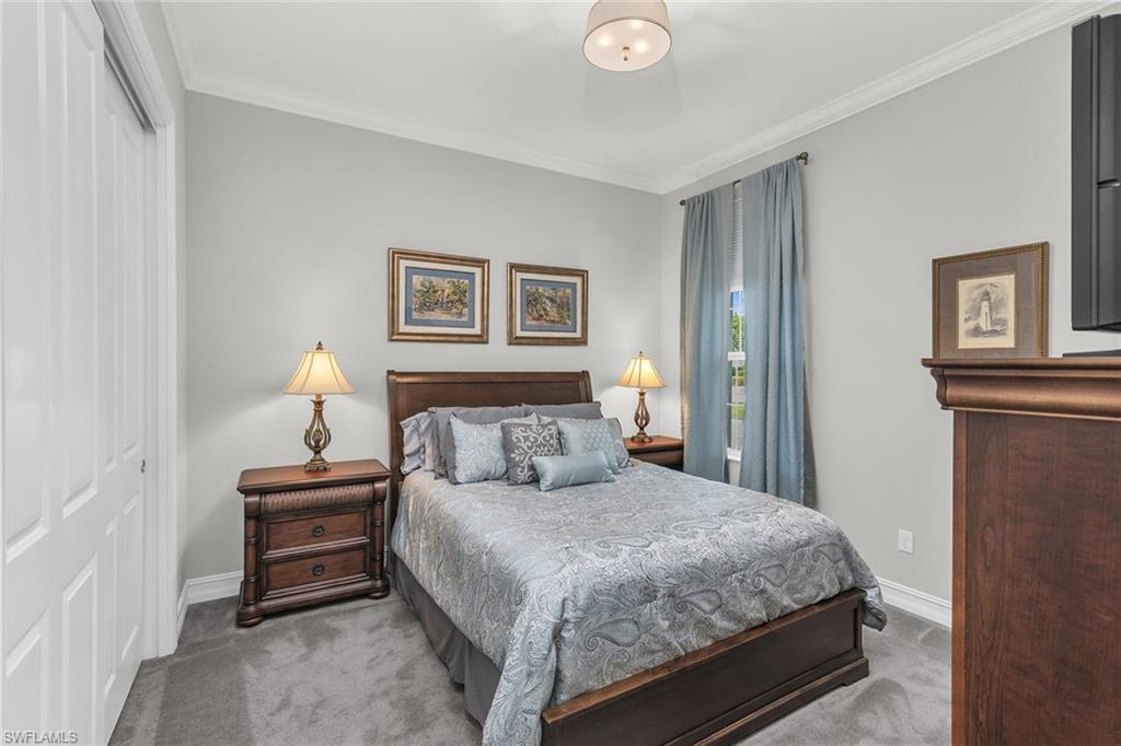 14812 Dockside Lane Naples, FL 34114 - Photo 21 of 49 a bedroom with a bed and a lamp with wooden floor