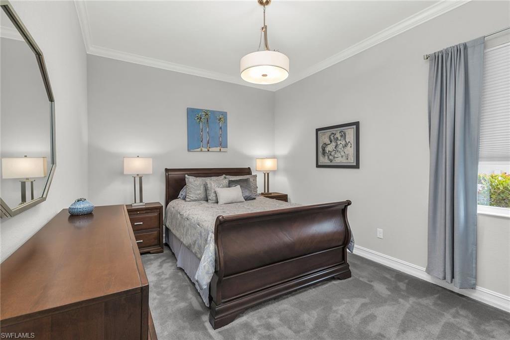 14812 Dockside Lane Naples, FL 34114 - Photo 23 of 49 a bedroom with a bed and a chandelier